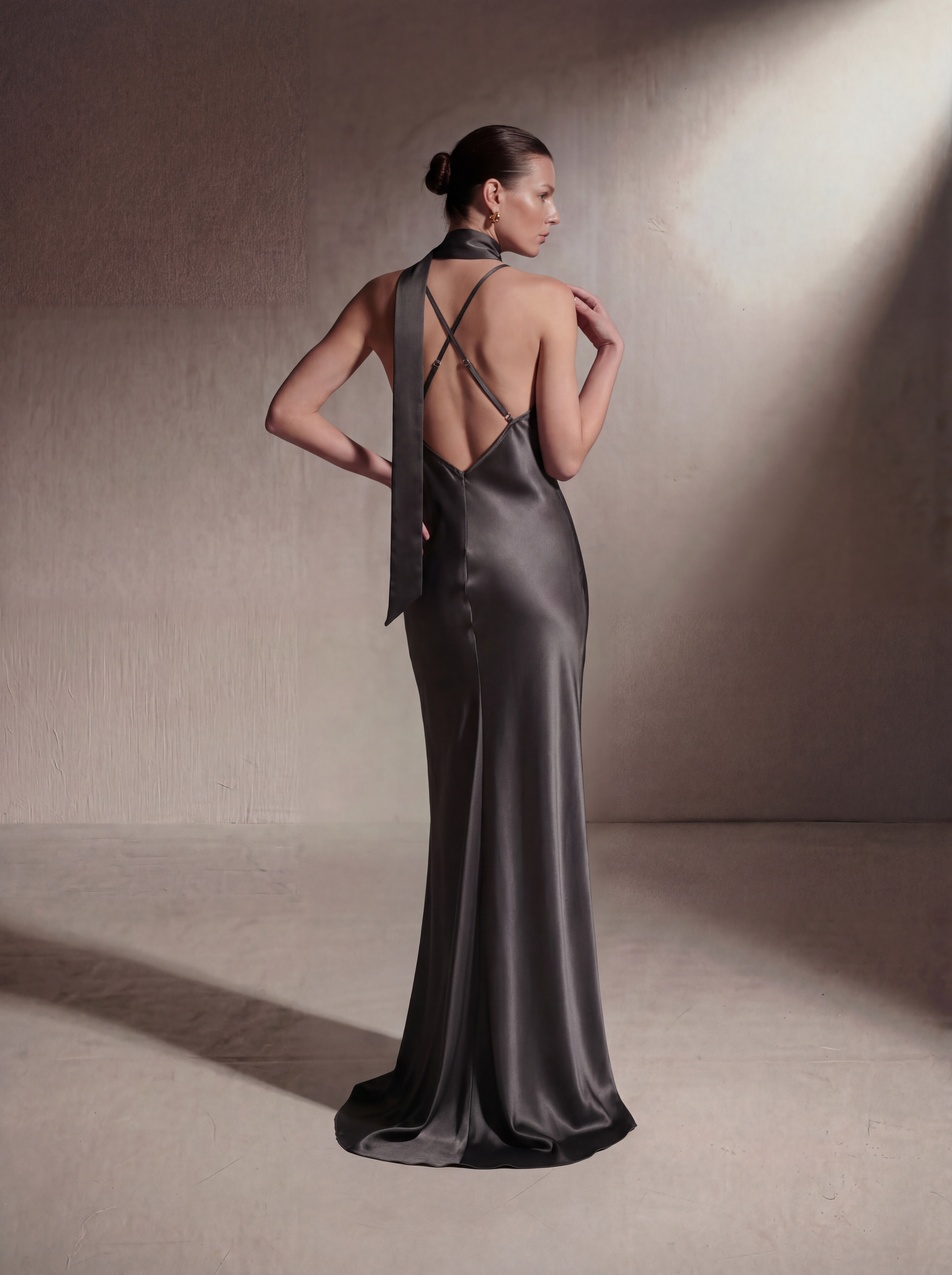 Woman wearing a Gunmetal silk slip gown, back view
