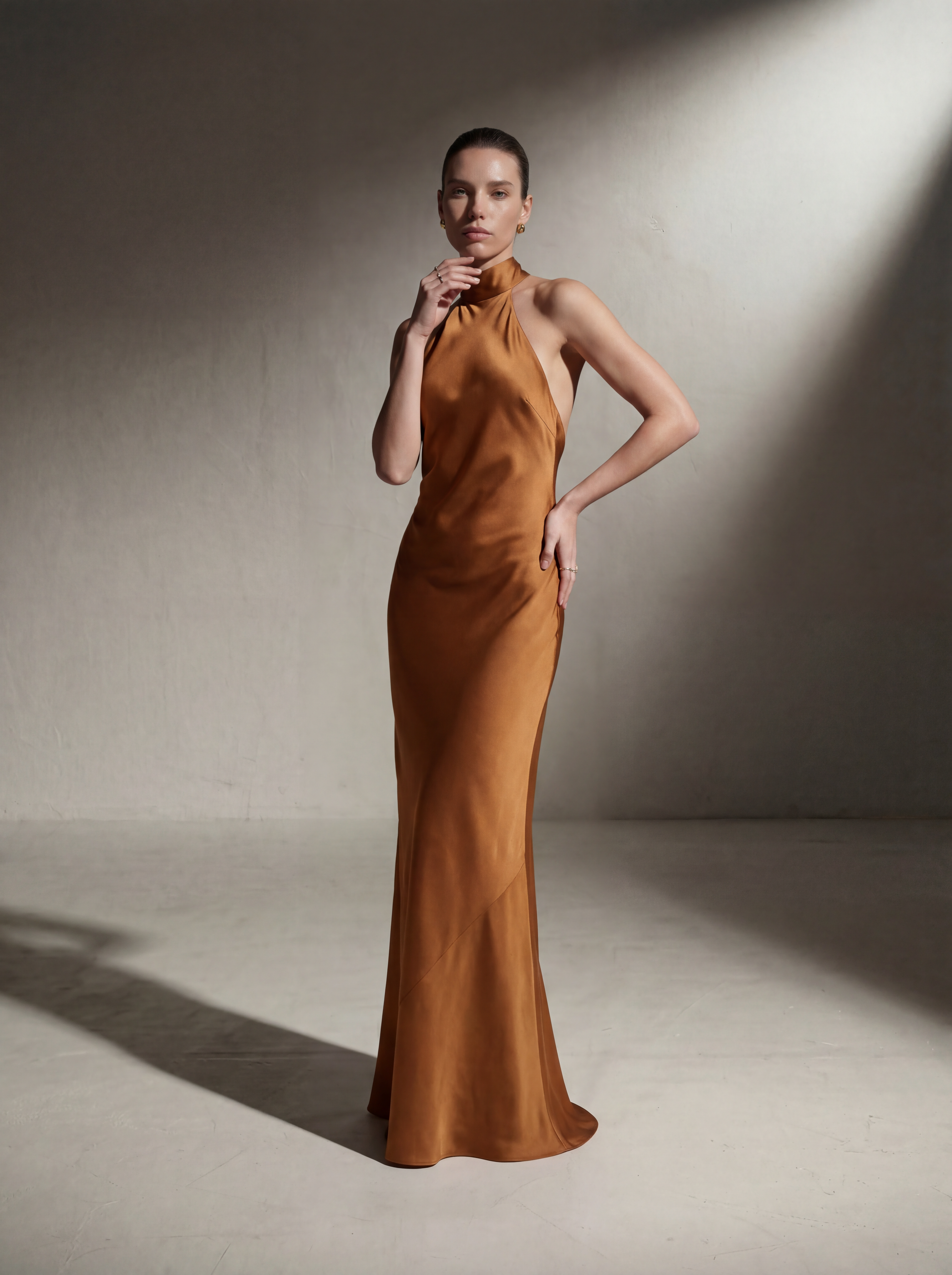 Woman wearing a Copper silk halter gown, front view