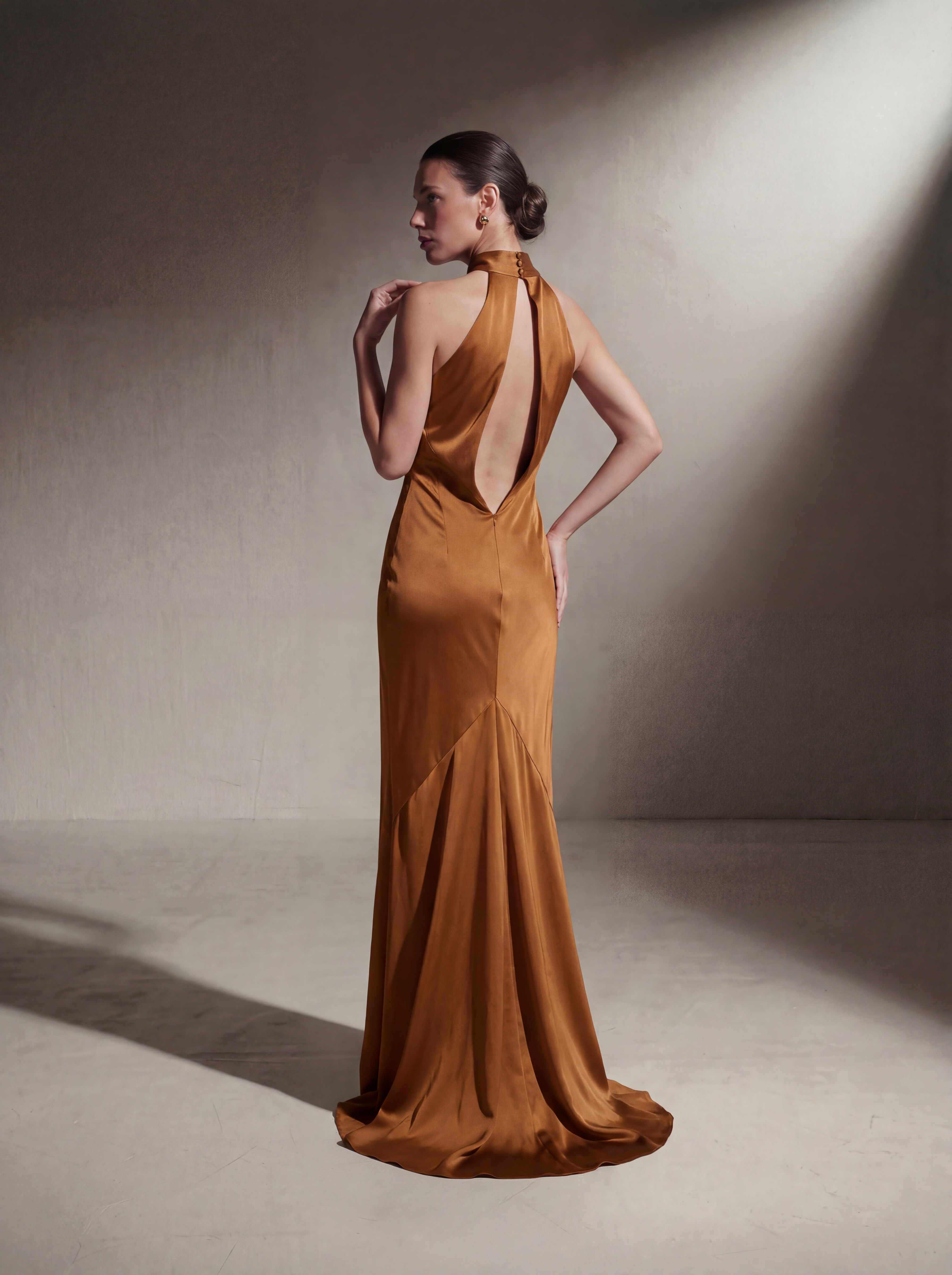 Woman wearing a Copper silk halter gown, back view