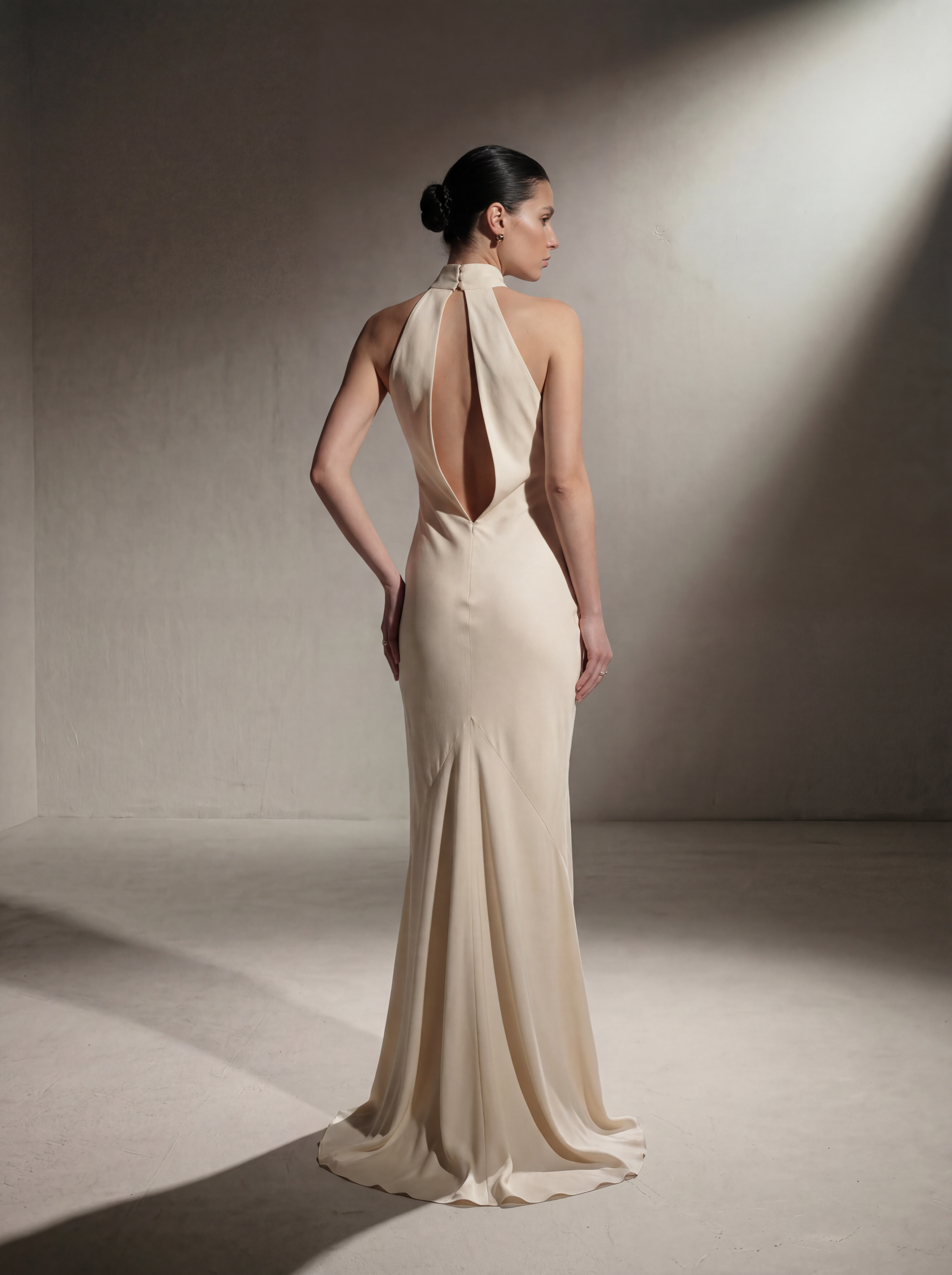 Woman wearing a Beige silk halter gown, back view