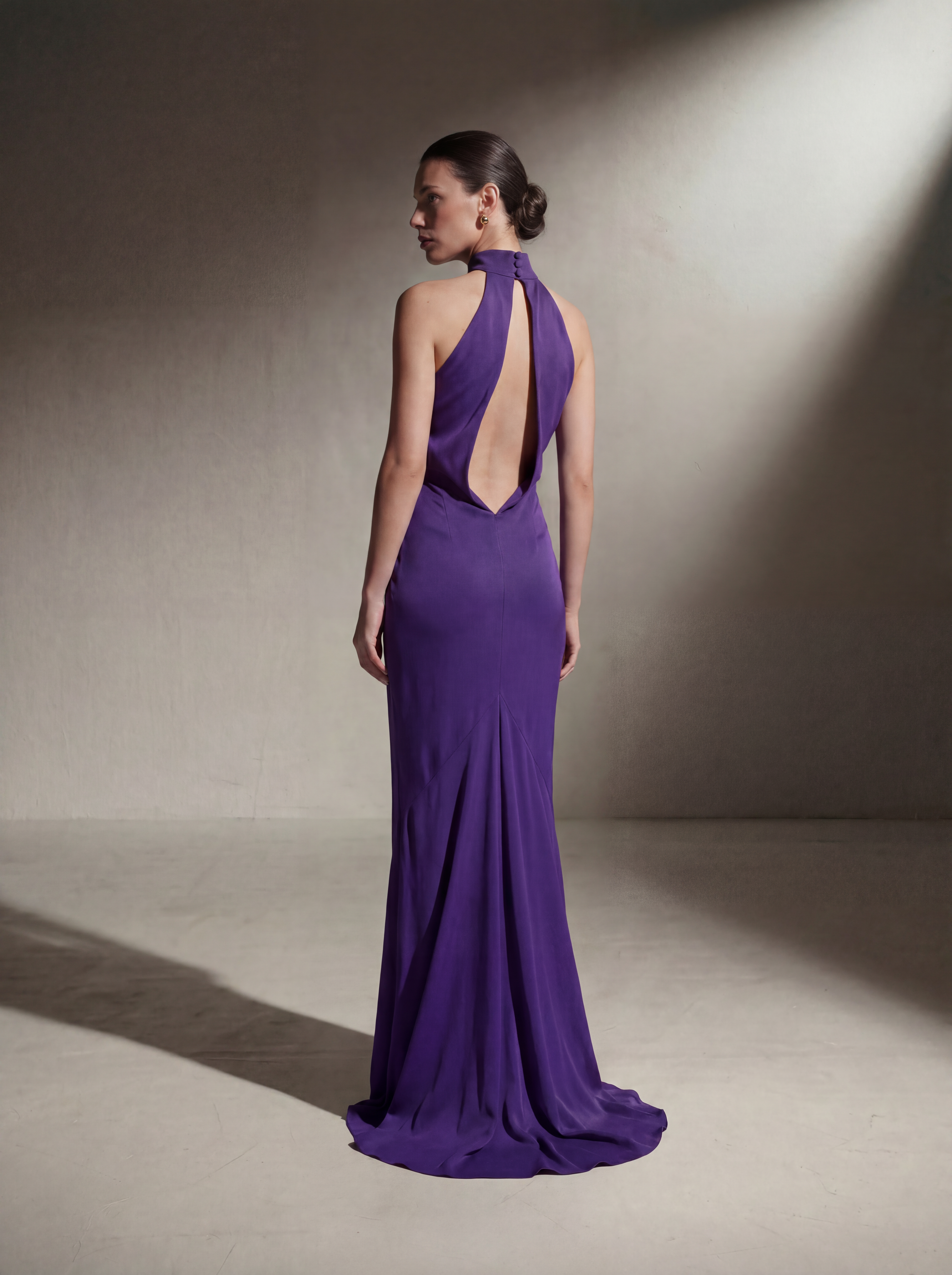 Woman wearing a Plum silk halter gown, back view