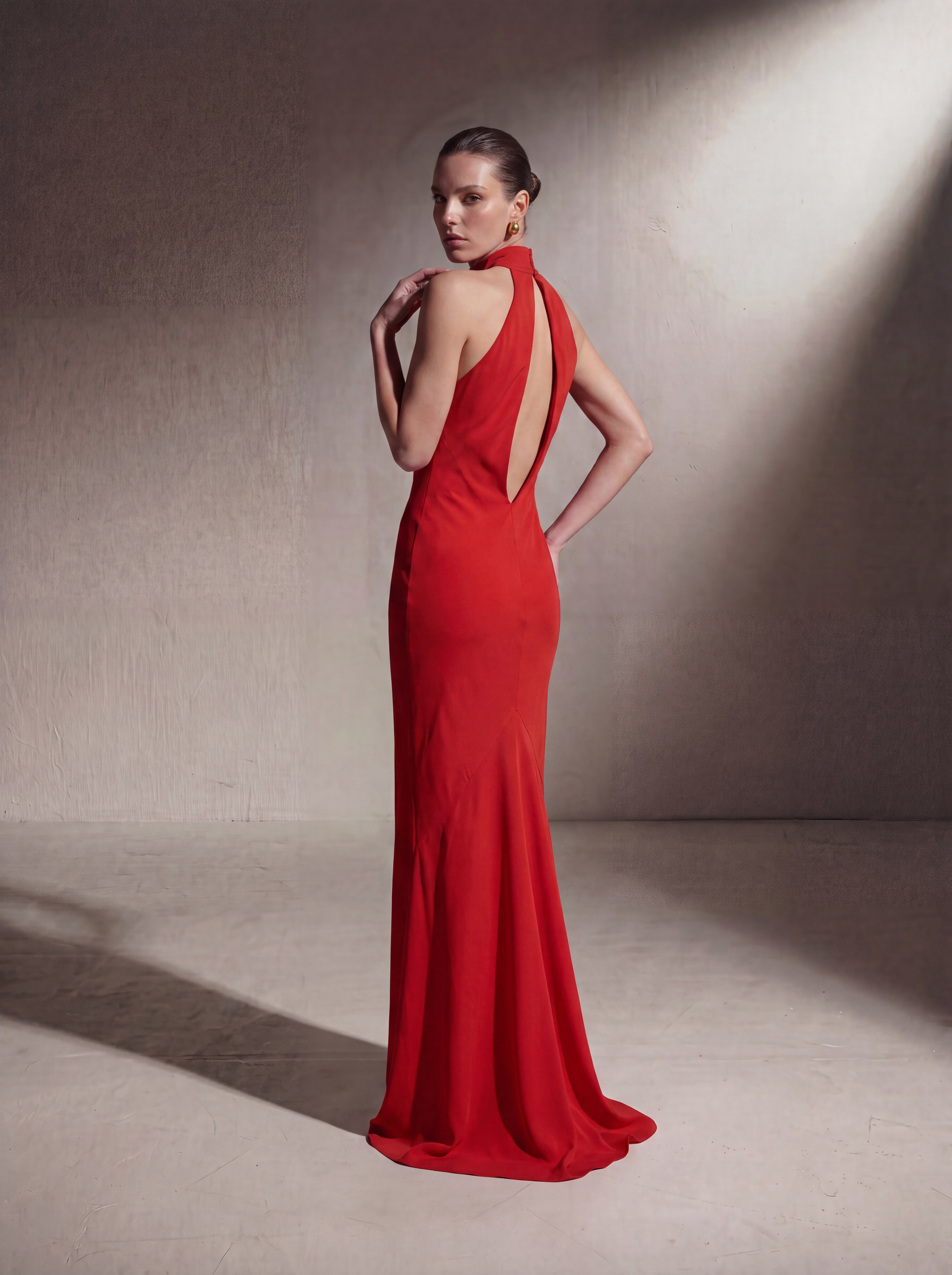 Woman wearing a Red silk halter gown, back view