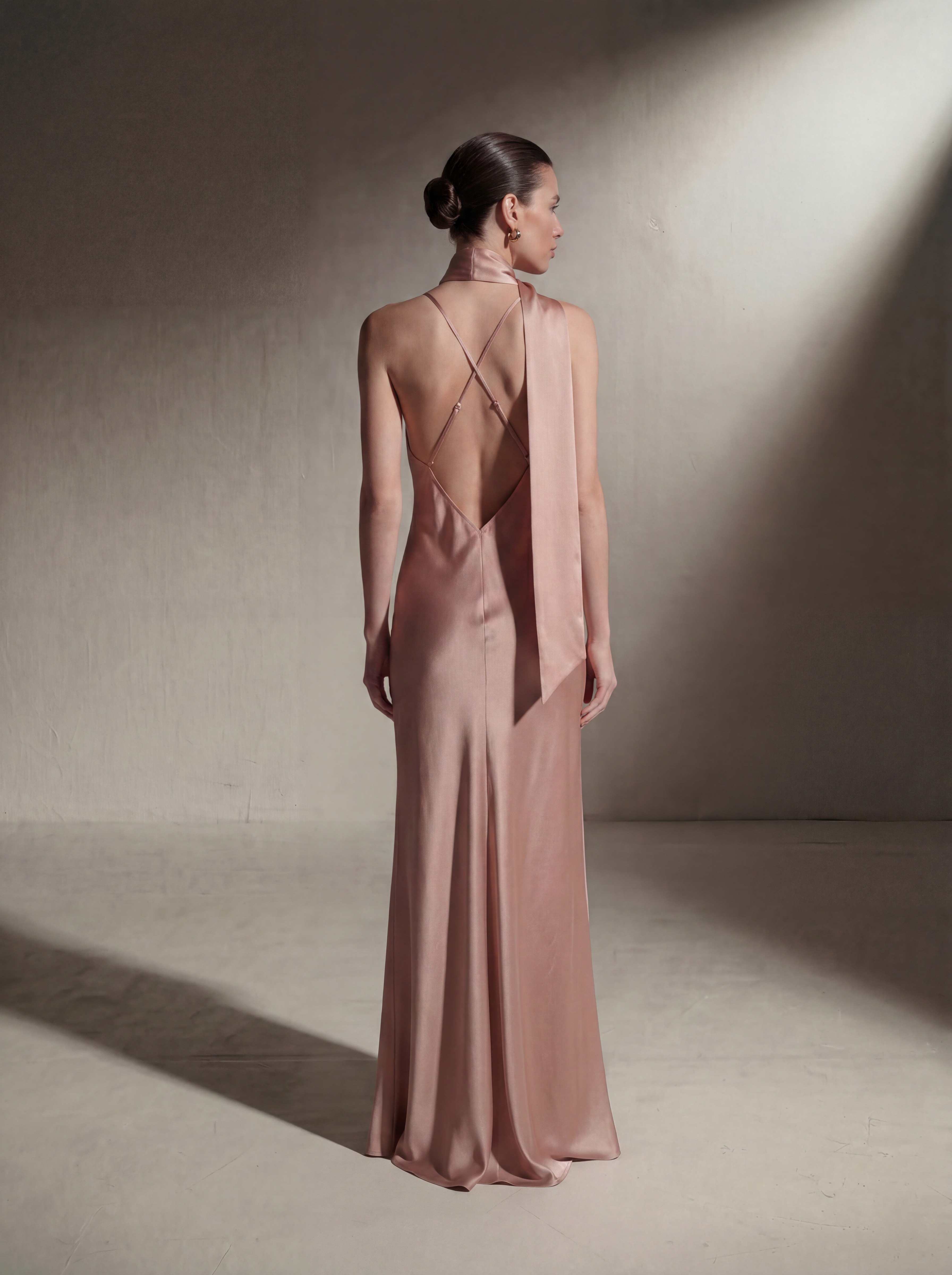 Woman wearing a Blush silk slip gown, back view